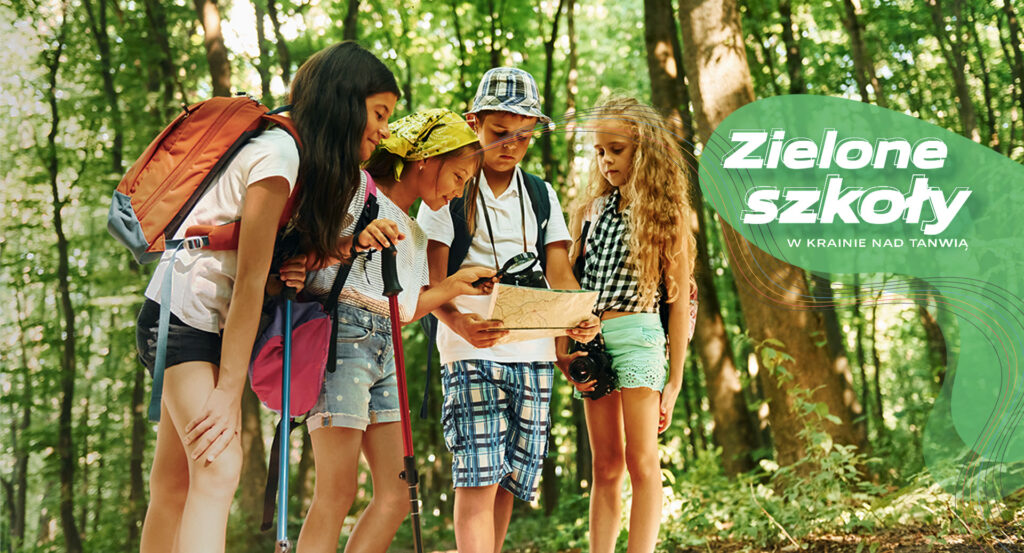 Zielone szkoły na Roztoczu – grupa dzieci z mapą w lesie, baner ośrodka Kraina nad Tanwią